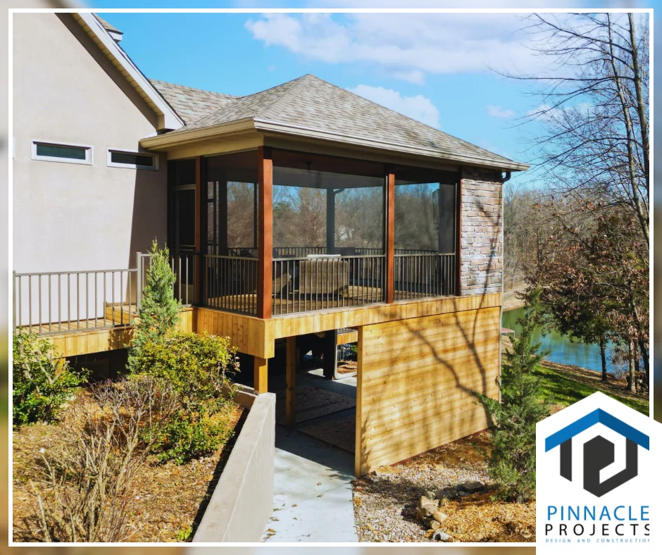 Screened porch above a concrete walkway, with trees and water; logo “Pinnacle Projects—Design and Construction”