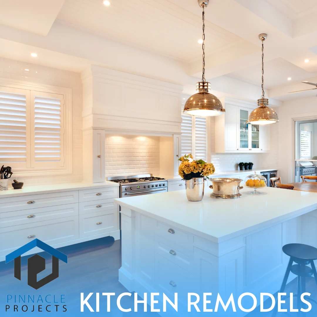 White kitchen with island, brass pendant lights and flowers; text reads “PINNACLE PROJECTS” and “KITCHEN REMODELS”